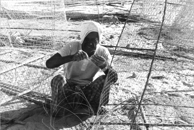 OCTOBER 1978: A fish trap maker. The older craftsmen have years of scars on their hands from the sharp wire.
